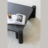 Macro view of the square tabletop surface highlighting the matte black oak finish and organic wood grain