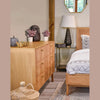 Studio lifestyle shot showcasing the dresser's low-profile silhouette in a bright, minimalist bedroom setting
