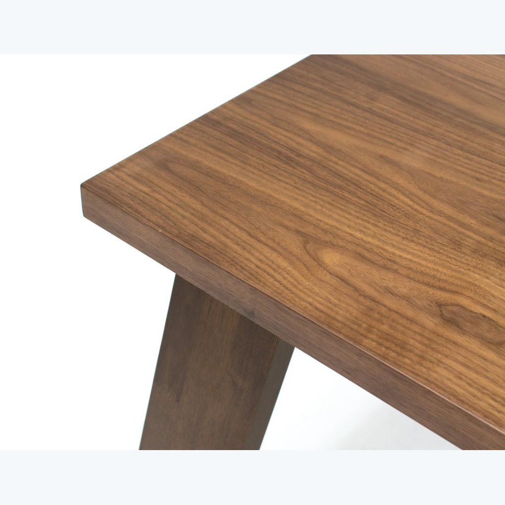 Detailed shot of the substantial tapered block leg showcasing unique wood grain patterns and a polished finish