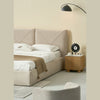 Lifestyle view showcasing the headboard under warm ambient light highlighting the depth of the V-shaped stitching