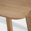 Close-up shot focusing on the soft rounded corner and smooth beveled edge of the light brown wood tabletop