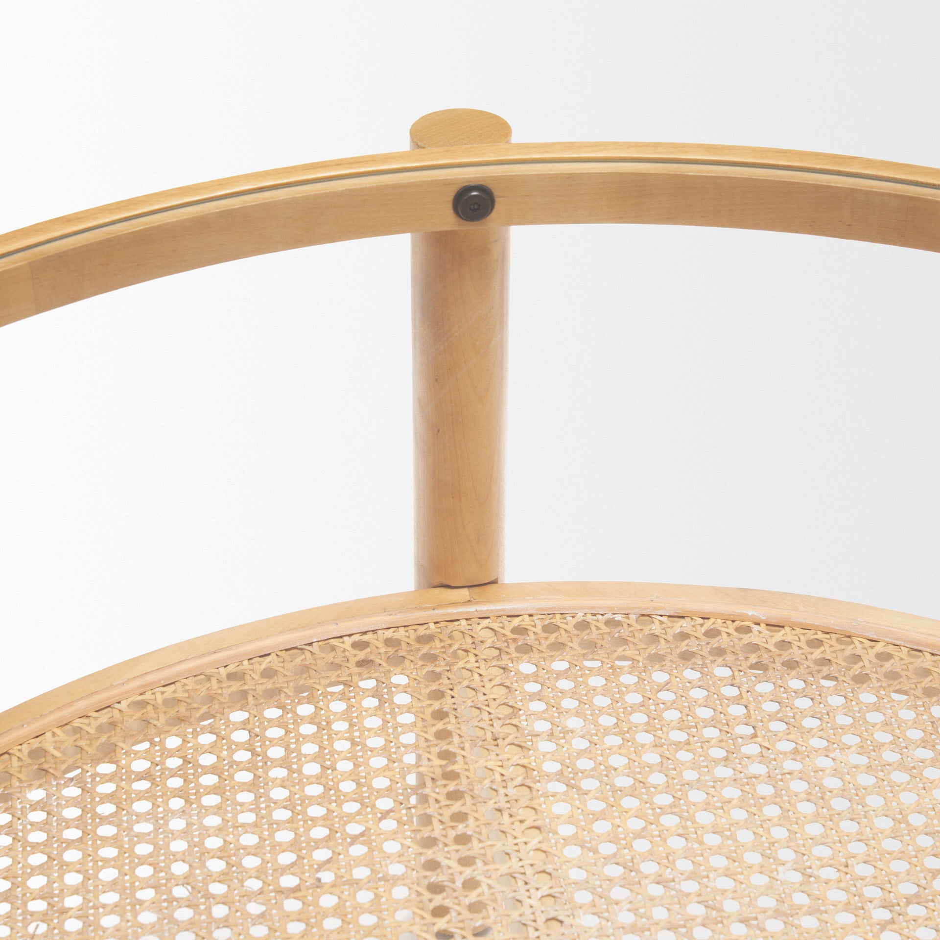 Front view of the Weslyn coffee table featuring a circular glass top and a natural woven cane lower storage shelf