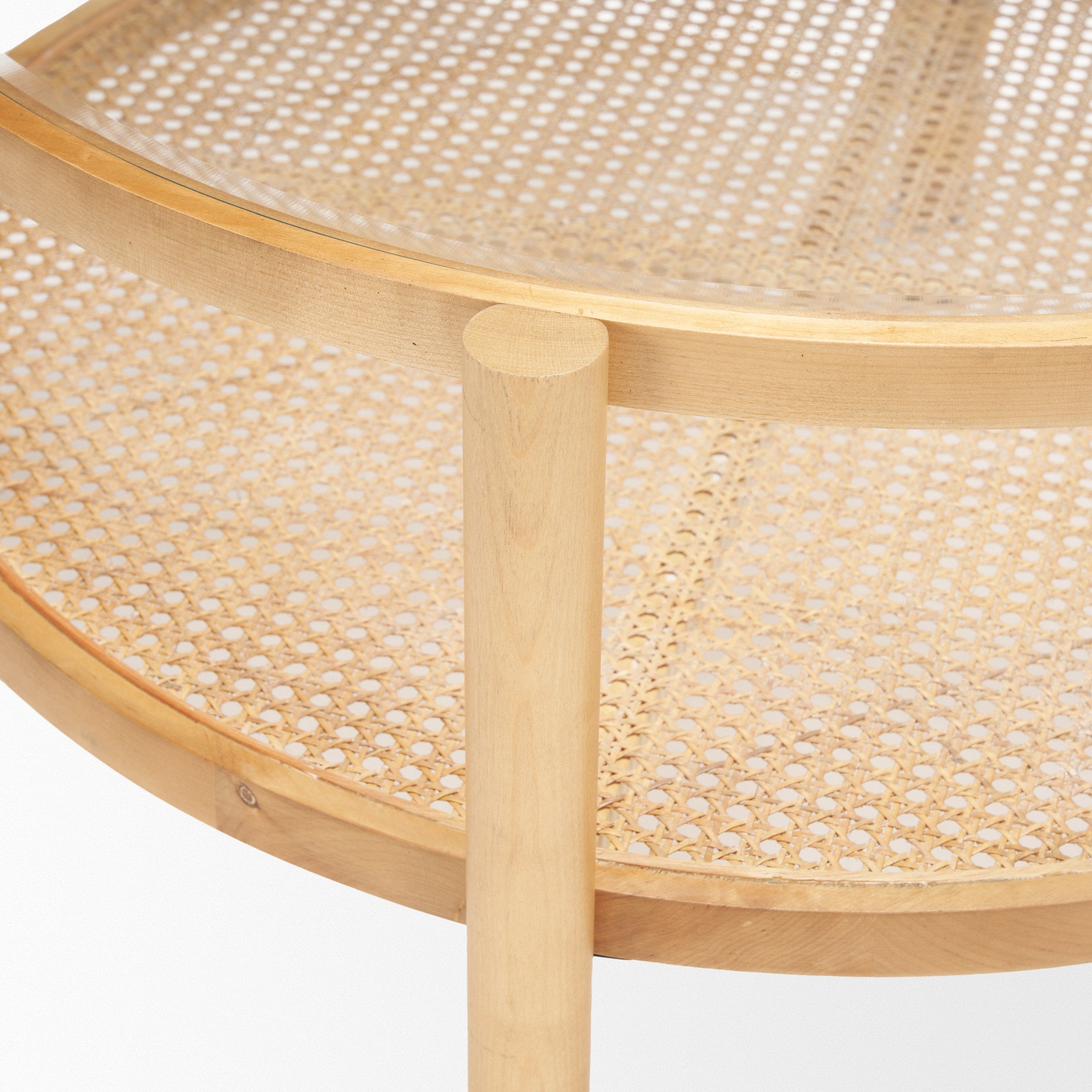 Front view of the Weslyn coffee table featuring a circular glass top and a natural woven cane lower storage shelf