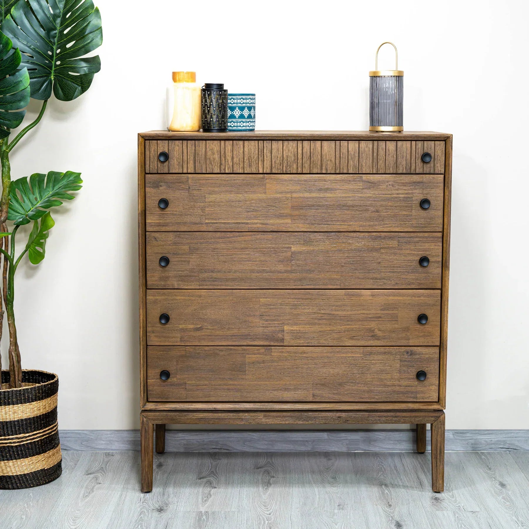 Front view of the West 5-drawer vertical chest featuring a rich natural wood finish, dark circular knobs, and a top drawer with vertical fluted detailing