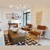 Interior view showing the West coffee table paired with leather mid-century modern accent chairs