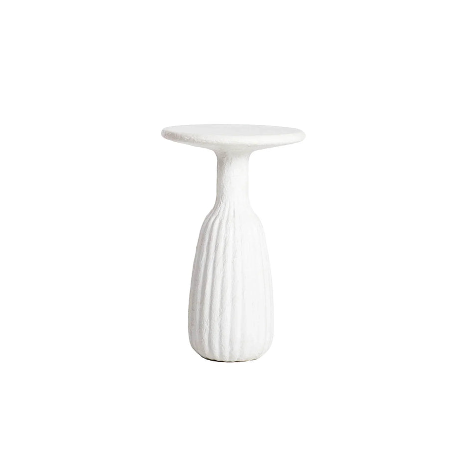 Front view of a white minimalist side table featuring a circular top and a unique fluted hourglass pedestal base with a textured plaster-like finish