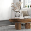 Wide-angle lifestyle view of the wood table as a central anchor in a light-filled living space