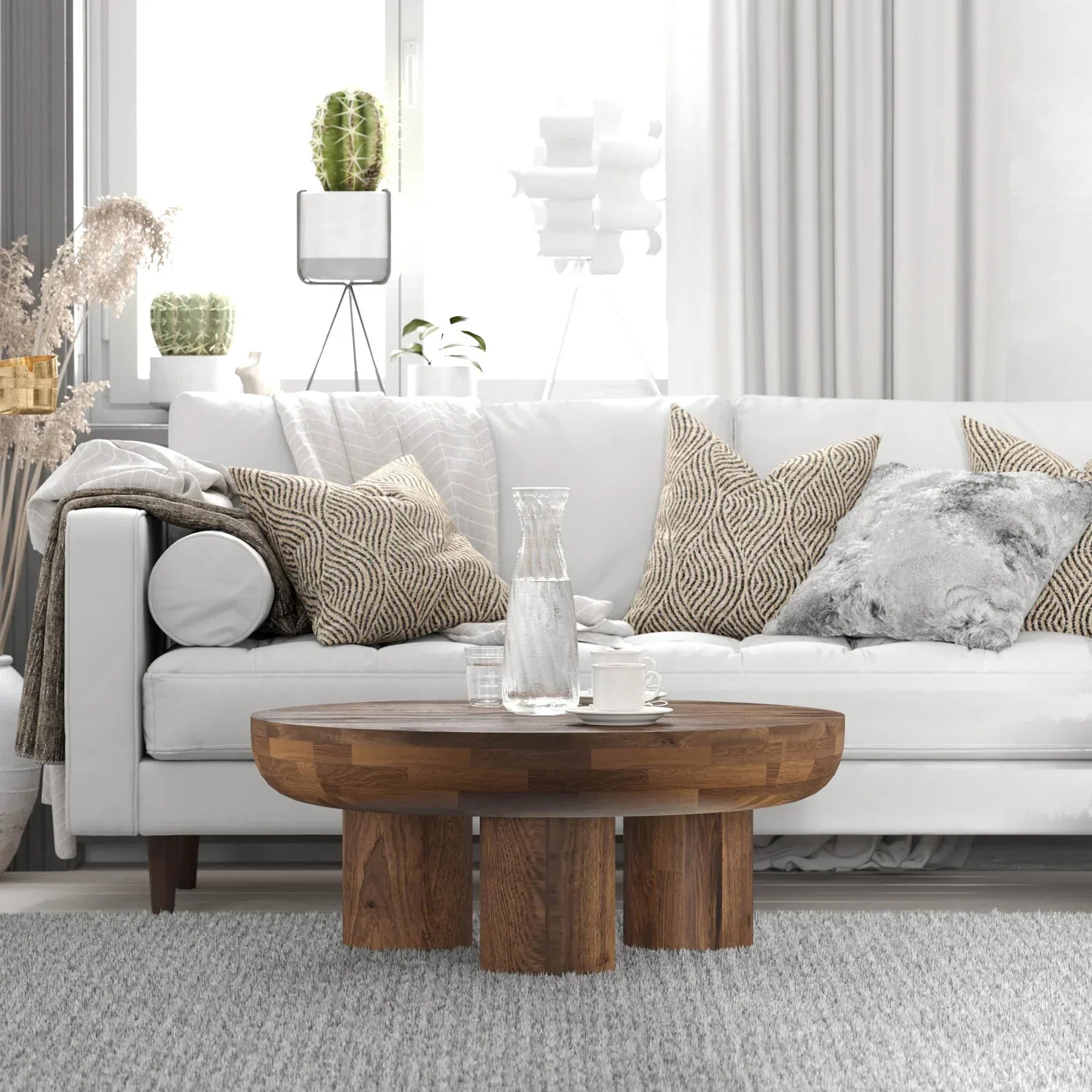 Front view of the Wilder round coffee table featuring a thick solid wood top and three chunky cylindrical pedestal legs