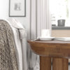 Lifestyle perspective showing the Wilder table styled next to a white contemporary sofa as a functional living room accent