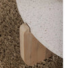 Close-up macro shot highlighting the smooth speckled terrazzo surface and the unique notched wood leg construction