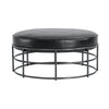 Studio shot of the Ziggy black leather ottoman demonstrating its scale and sculptural metal frame