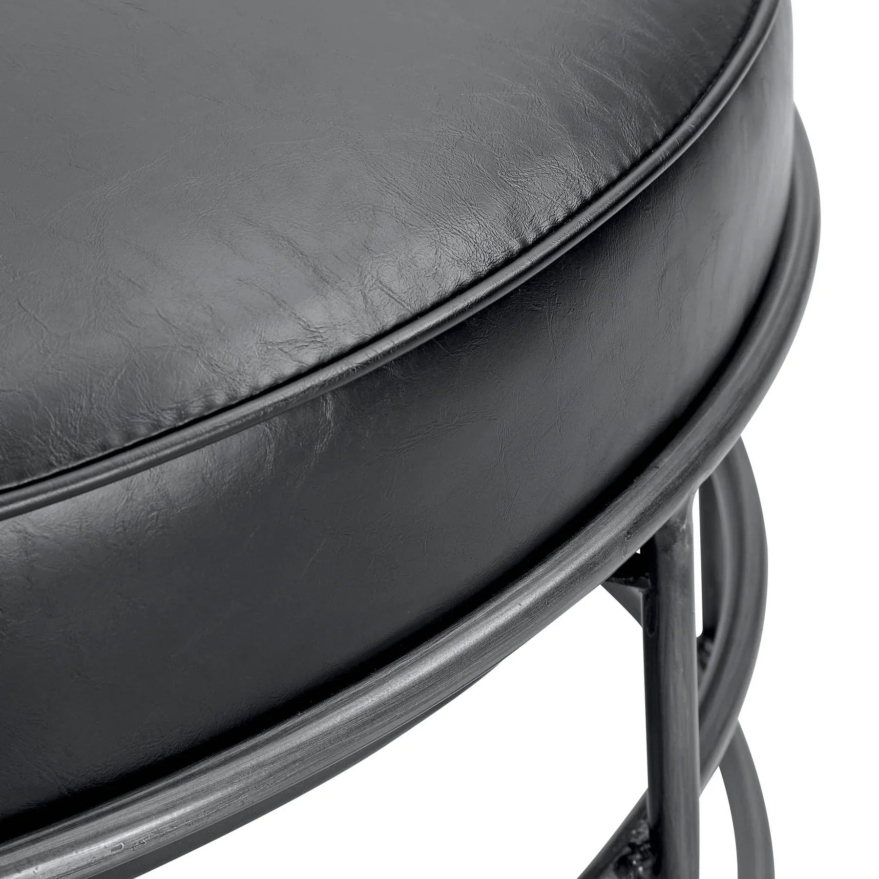Front three-quarter view of the Ziggy round ottoman featuring a black leather top and a minimalist circular metal cage base