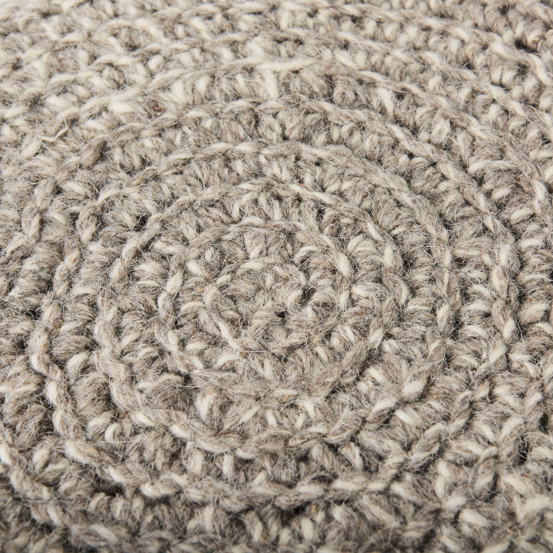 Front three-quarter view of the Bina accent stool featuring a thick gray knitted wool seat and four natural wood legs