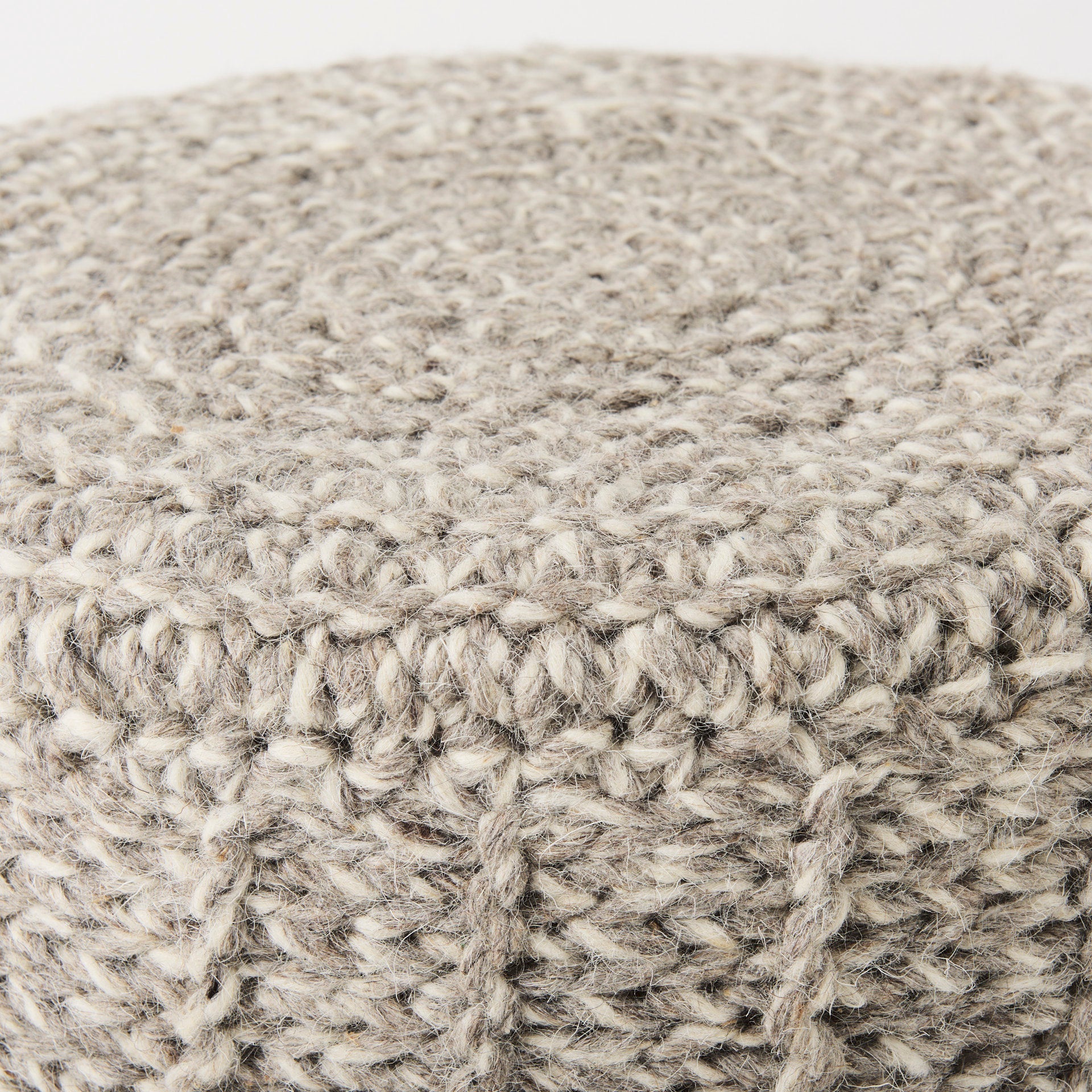 Front three-quarter view of the Bina accent stool featuring a thick gray knitted wool seat and four natural wood legs