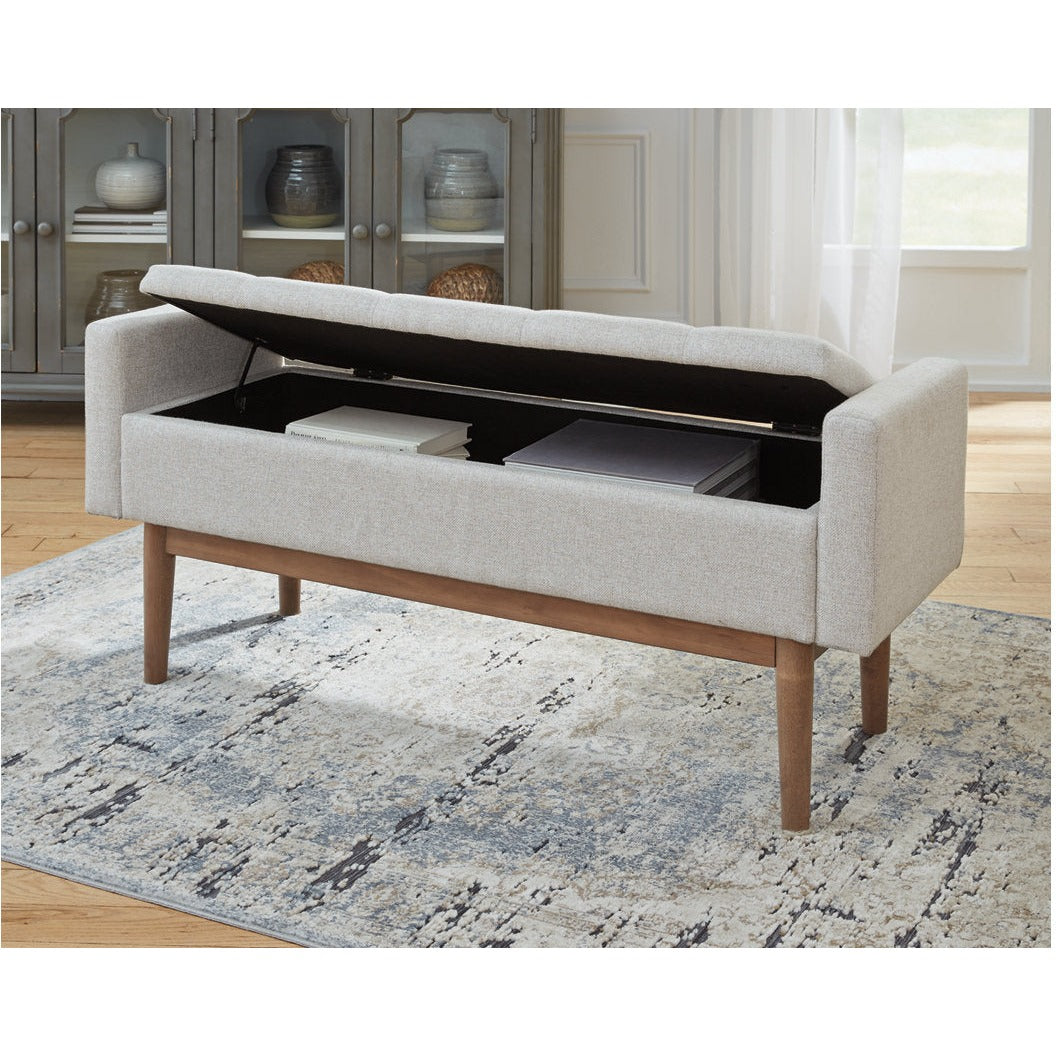 Front view of the Briarson storage bench featuring light gray button-tufted upholstery and natural wood tapered legs
