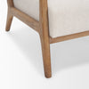 Macro shot of the light oak leg and the textured ivory fabric of the Cashel seat cushion