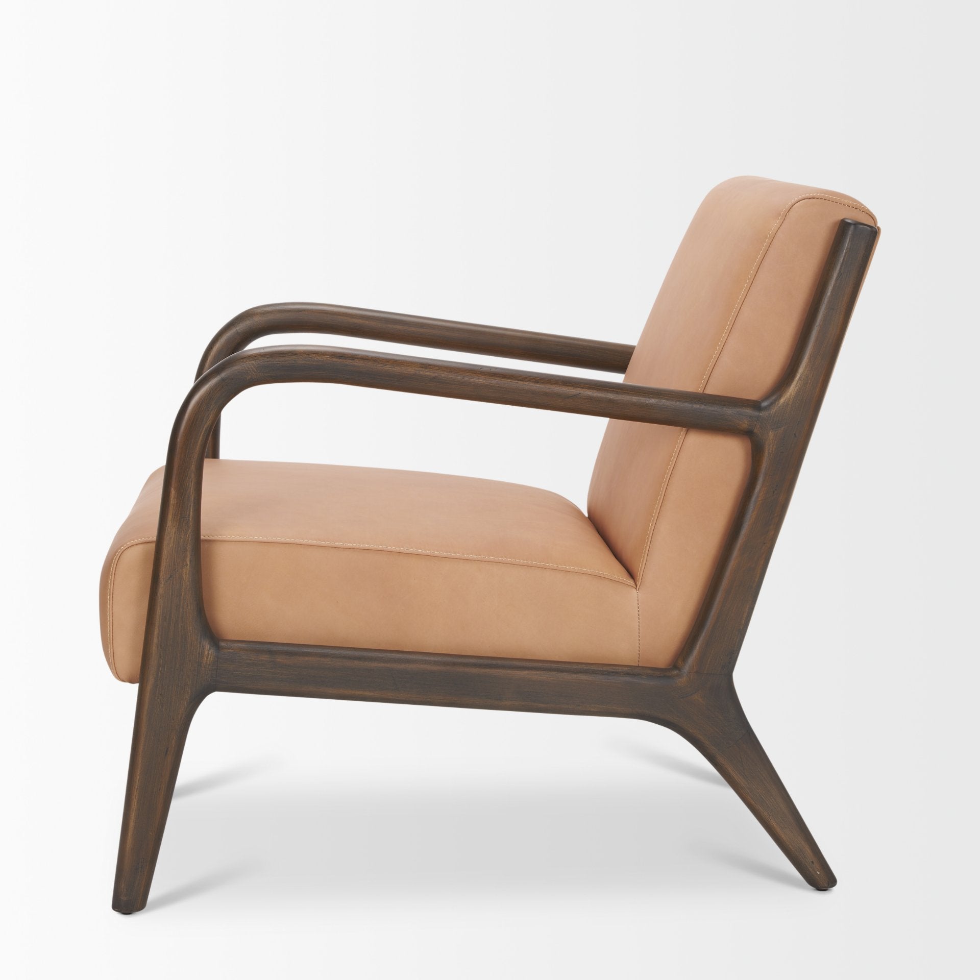 Side profile of the tan leather Cashel chair showing the contrast with the dark wood frame