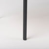 Close-up shot focusing on the minimalist black metal leg and the smooth matte finish of the industrial frame