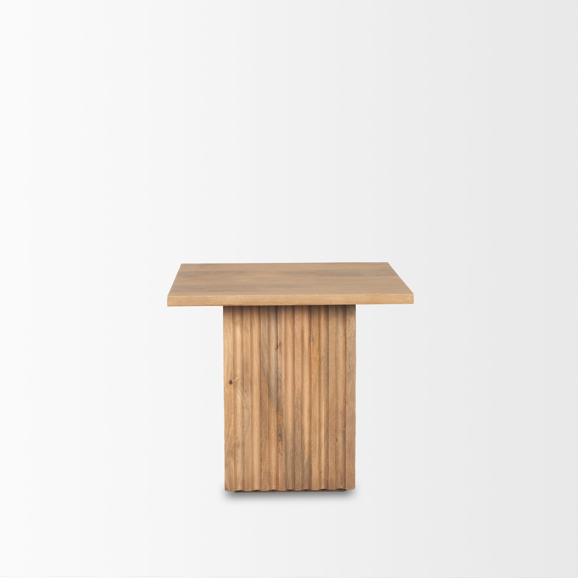 Perspective view of the June side table featuring a square tabletop and a thick square fluted pedestal base in natural mango wood