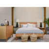 Lifestyle shot featuring the Colton bed styled with gray bedding and matching oak furniture in a bright, modern master suite