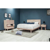 Studio lifestyle view showcasing the bed alongside matching wood dressers and minimalist decor