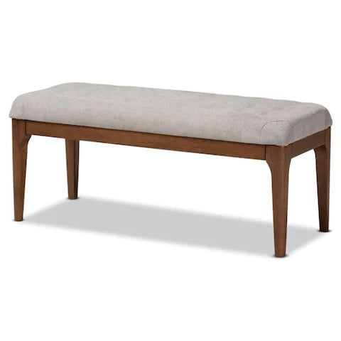 Front view of the Ettore dining bench featuring a warm walnut wood frame and a light neutral tufted fabric seat