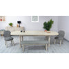 Wide-angle lifestyle view of the table in its fully extended form paired with coordinating grey dining chairs