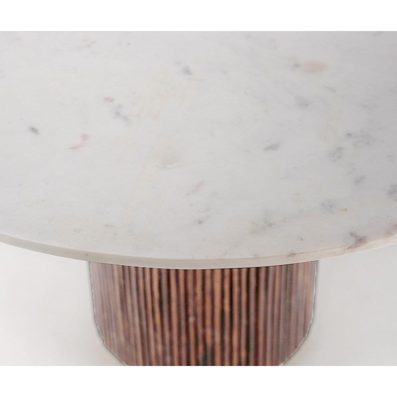 Front view of the Fifi round dining table featuring a sleek white marble top and a decorative fluted wood pedestal base with a gold metal plinth