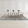 Wide-angle lifestyle shot featuring the table fully extended and paired with six grey and black upholstered chairs
