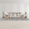 Front lifestyle perspective of the table styled with grey upholstered chairs in a bright open-concept room