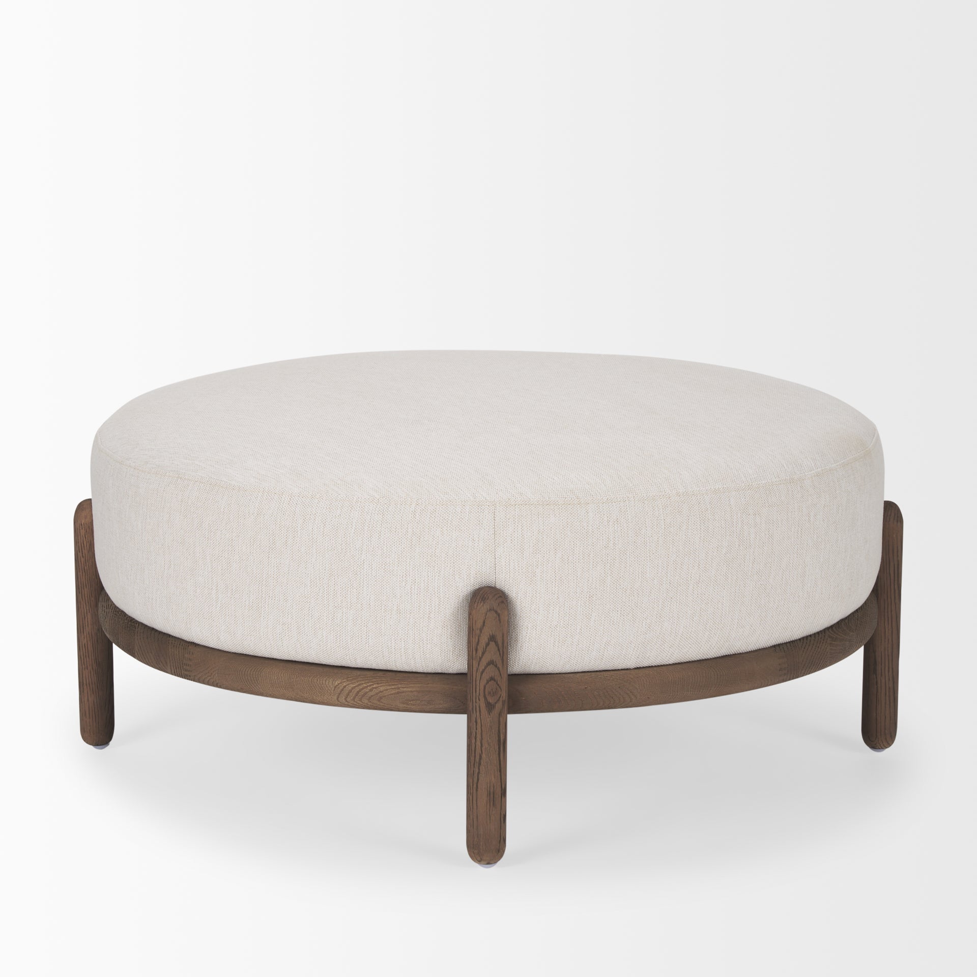Front three-quarter view of the Gwynn ottoman featuring a cream upholstered seat and a curved oak wood frame