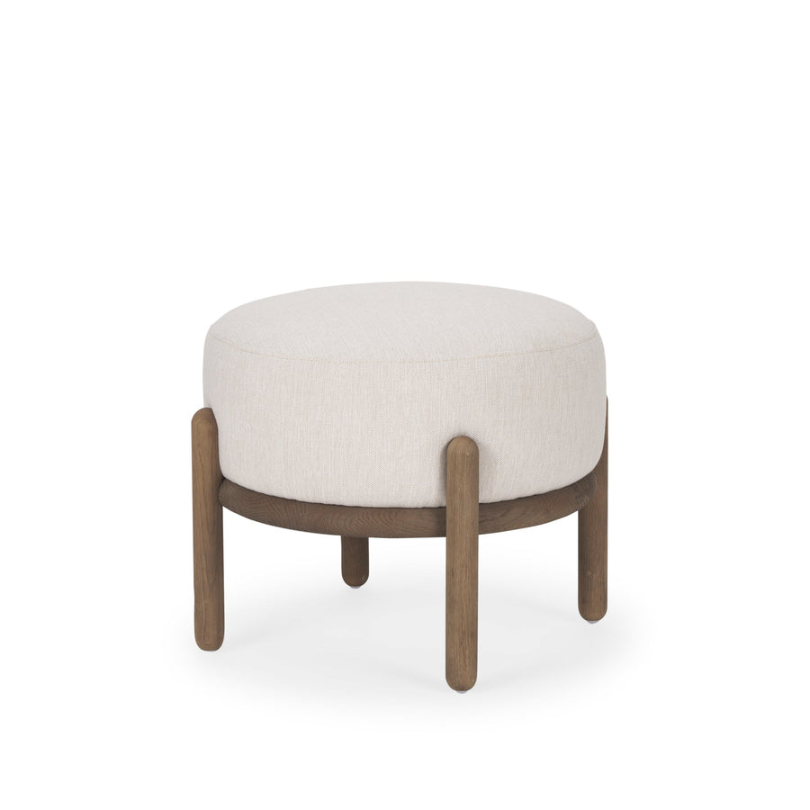 Front three-quarter view of the Gwynn pouf featuring a cream upholstered seat and a curved oak wood frame