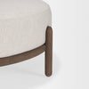 Detailed perspective showing the intersection of the cream fabric seat and the natural wood support frame