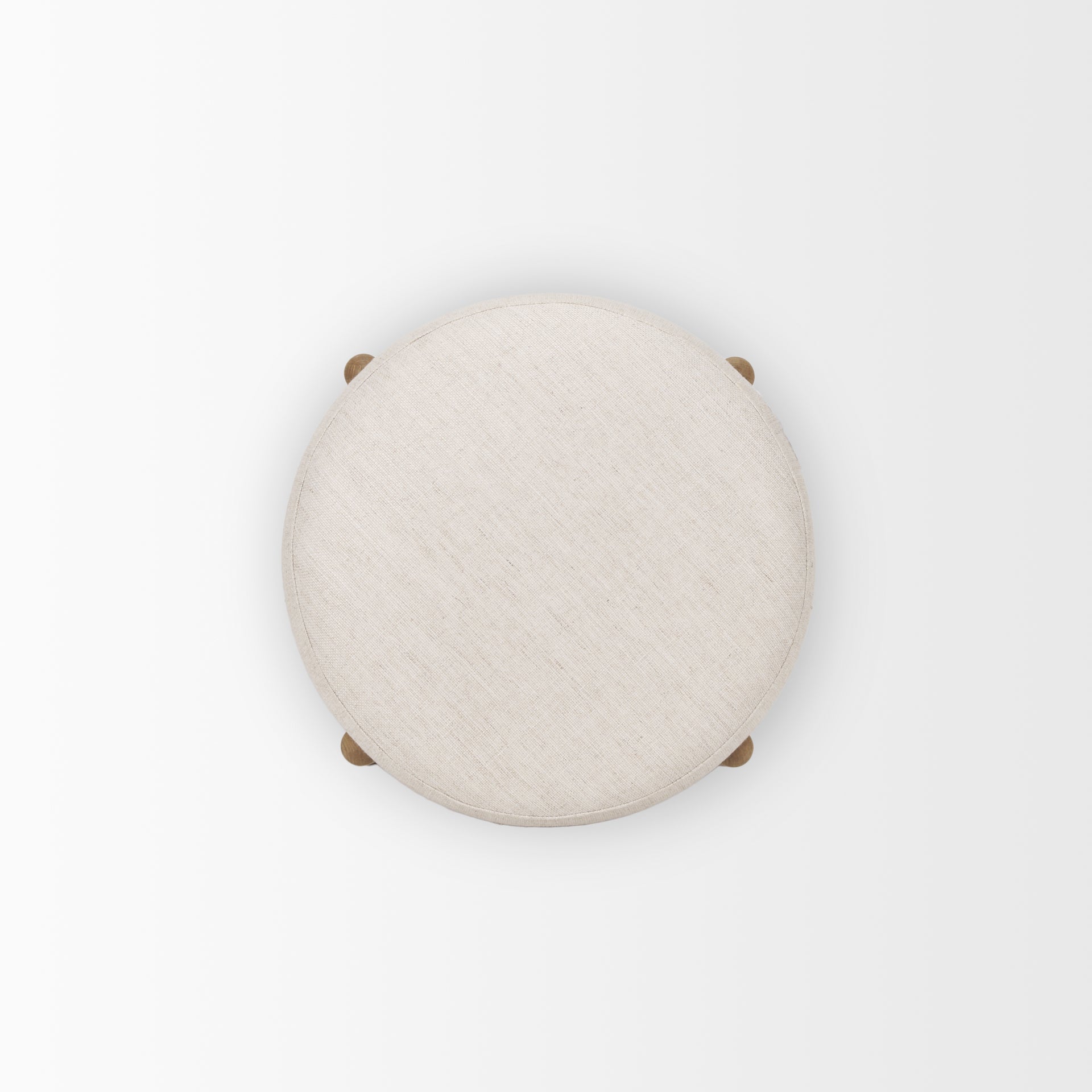 Front three-quarter view of the Gwynn pouf featuring a cream upholstered seat and a curved oak wood frame