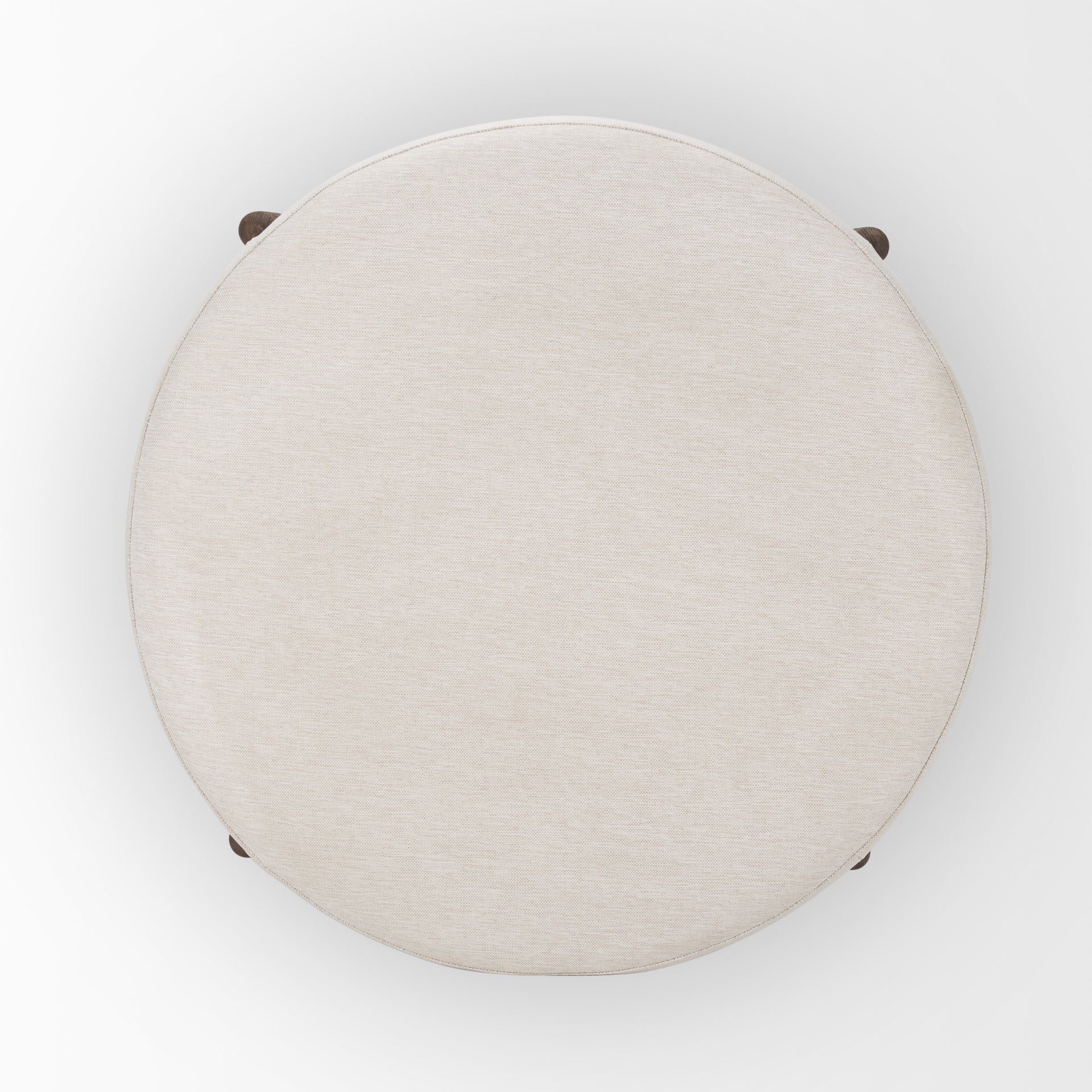 Front three-quarter view of the Gwynn ottoman featuring a cream upholstered seat and a curved oak wood frame