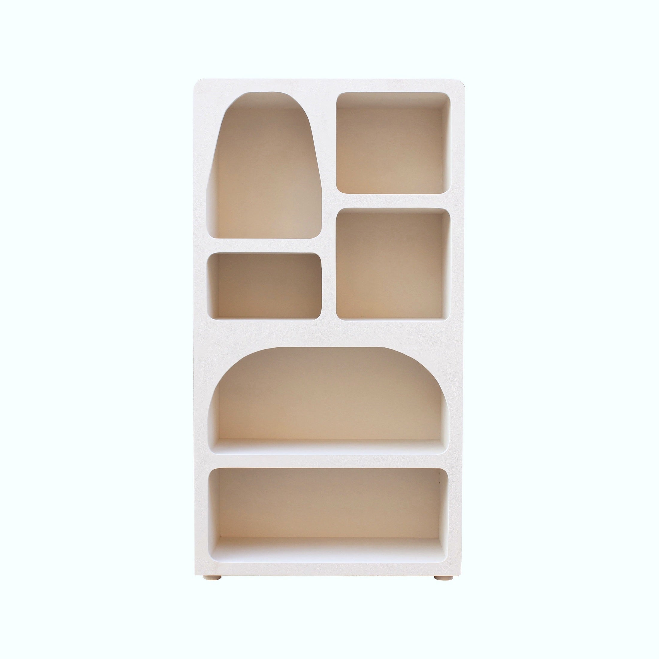 Straight-on front view of the Inga bookshelf featuring a sculptural asymmetrical layout with arched and rectangular display niches in a matte white finish