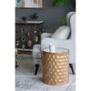 Kiran gold side table styled next to a light grey wingback armchair