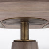 Close-up perspective focusing on the antique brass metal neck connecting the wooden tabletop to the tapered pedestal base