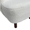 Detailed view of the natural wood grain on the arched armrest and the textured fabric seat