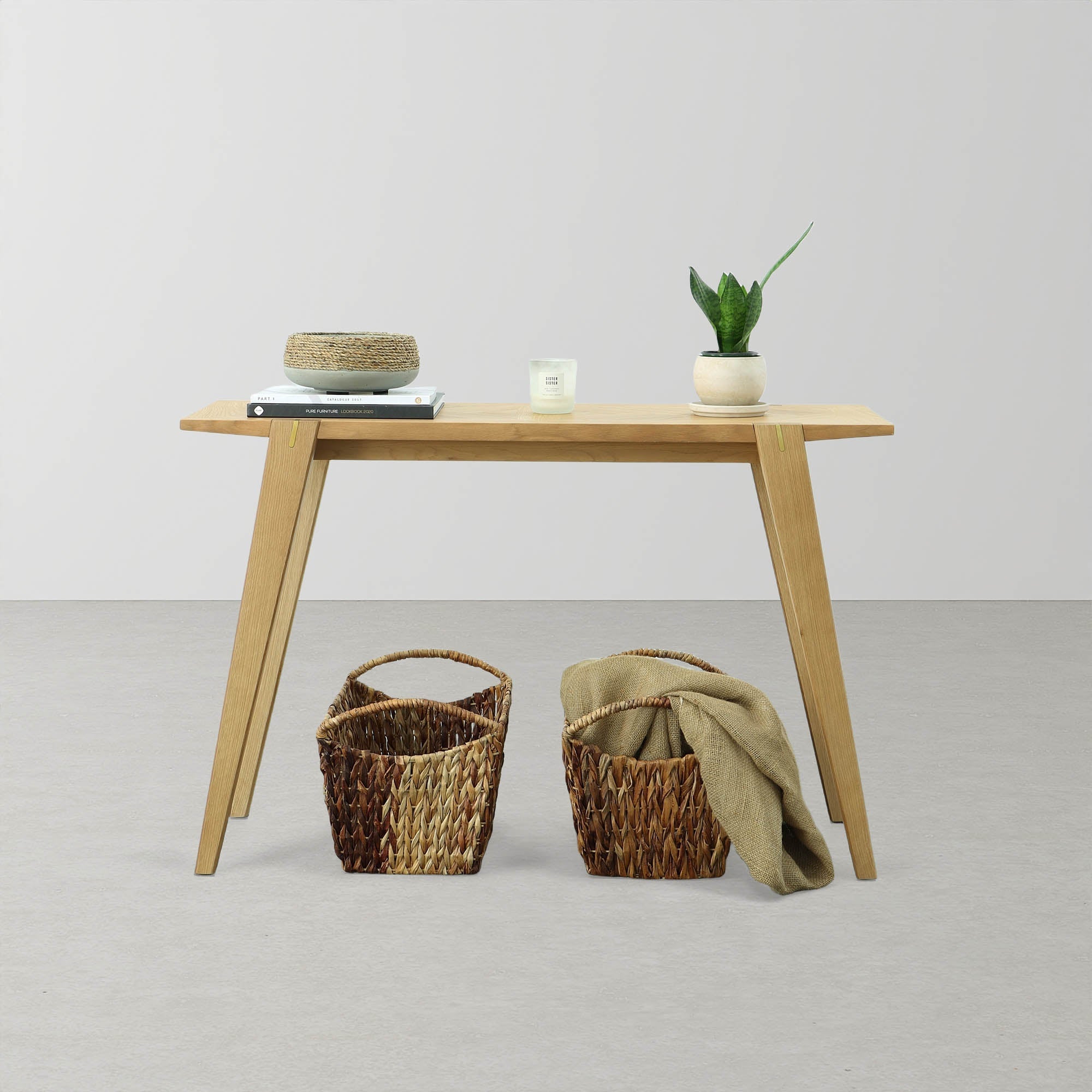 Front view of the Colton console table in natural oak featuring a minimalist design with slim tapered legs and exposed joinery