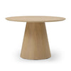Three-quarter perspective view highlighting the clean architectural lines and smooth circular top of the oak dining table