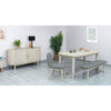 Studio lifestyle shot featuring the Oasis table styled with a matching wooden bench and two upholstered chairs