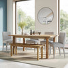 Bright lifestyle shot featuring the Bodhi dining table paired with a matching wood bench and light grey upholstered chairs