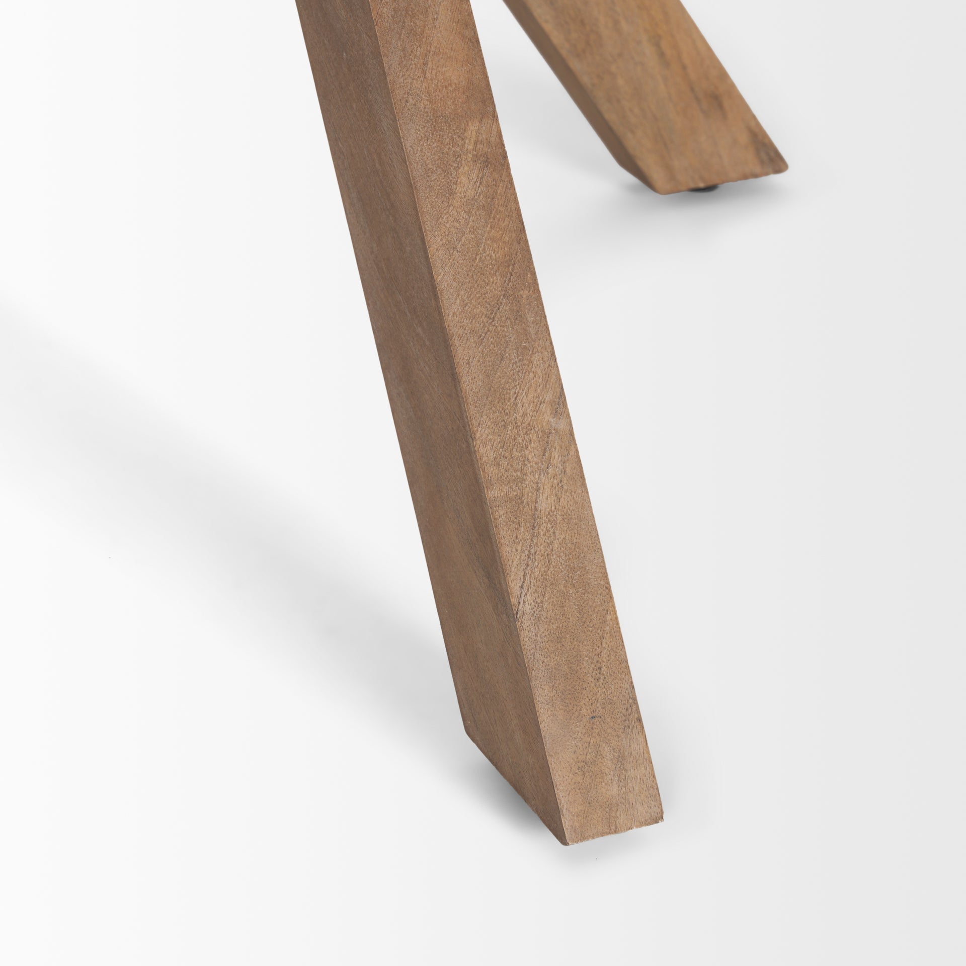 Three-quarter perspective view of the Solana foyer table featuring a circular top and a unique interlocking tripod base in light natural mango wood