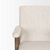 Close-up of the plushly padded oatmeal fabric armrest and its connection to the wooden support