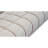 Close-up detail of the premium cream boucle fabric and soft-padded channel tufting