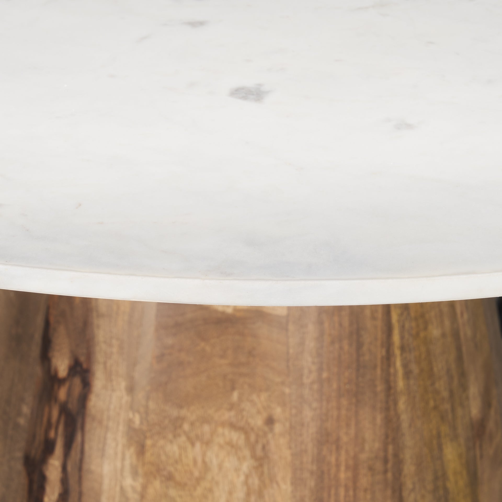 Front view of the Allyson round dining table featuring a white marble top and a solid mango wood tapered pedestal base